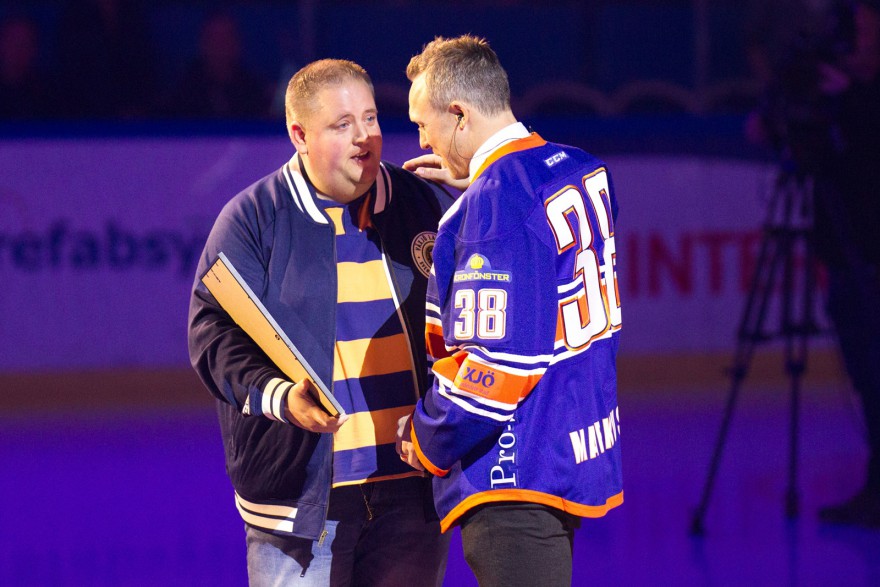 Lakejernas ordförande Johan Eliasson överlämnade en gåva till den forna lagkaptenen Johan Markusson under tröjceremionin under matchen i SHL mellan Växjö och Luleå på Vida Arena i VÄXJÖ den 1 oktober ( Foto: Lars Nilsson / Pic-Agency )